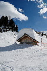 Alpin Hut on the Dolomite Alps with lots of snow on the roof. Winter landscape near the Falzarego Pass, Veneto, italy
