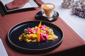 Vanilla pancakes with glazed fruits and fruit foam and coffee