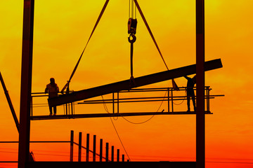 Industrial construction cranes and building silhouette with worker.