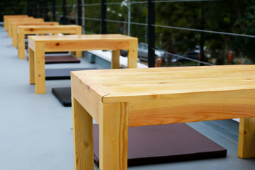 wooden picnic table on a green meadow with trees on background