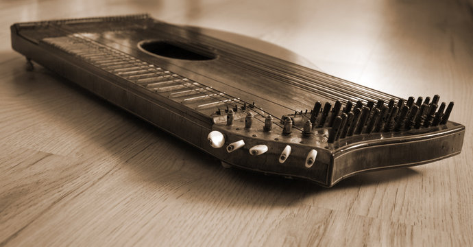Old zither lying on a wooden table.