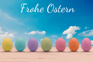 Colorful easter eggs on a wooden board with the happy easter lettering