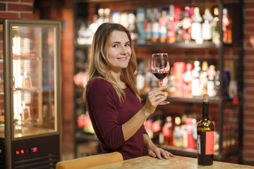 Attractive woman taste red wine in the restaurant