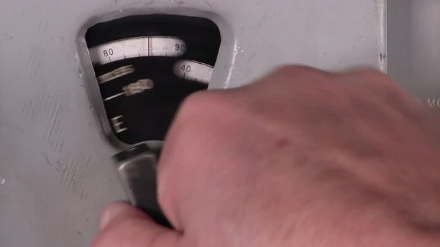 A rotary dial is adjusted to change frequency band on old electronic radio transmitter receiver hardware equipment