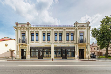 Fototapeta premium old beautiful with restored facade building in sunny day near the road. Urban development of the 19th century