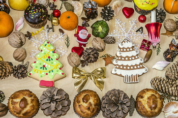 Muffins and biscuits spruce with different pine cones,nuts,citrus fruits and chocolate balls on plywood
 
