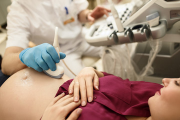 Obraz na płótnie Canvas Close up of ultrasound diagnostics doing on pregnant woman. Medical and maternity concept