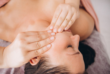 Face Massage. Close-up of a Young Woman Getting Spa Treatment