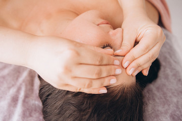 Fototapeta na wymiar Face Massage. Close-up of a Young Woman Getting Spa Treatment