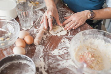 cropped shot of woman preparing cookies with cutter