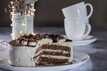 Chocolate Cake with Cream and Two  White Cups of Coffee .