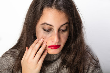 Depressed woman smearing her bright red lipstick