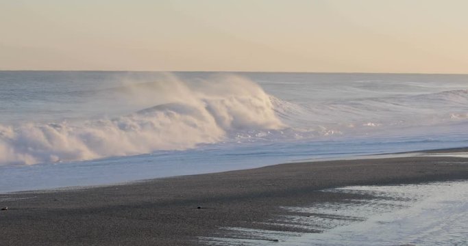 Oceano e mare mosso in tempesta con onde impetuose che si infrangono sulla spiaggia.