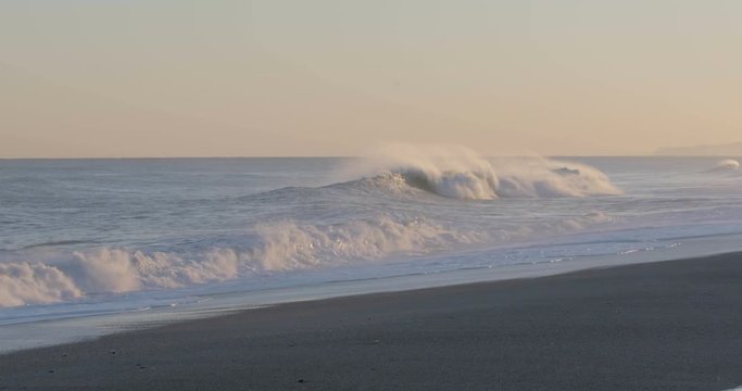 Oceano e mare mosso in tempesta con onde impetuose che si infrangono sulla spiaggia.
