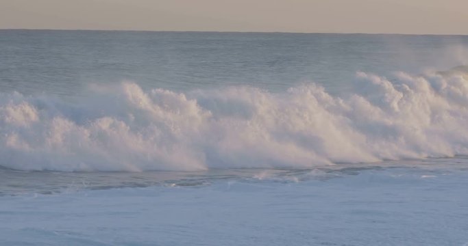 Oceano e mare mosso in tempesta con onde impetuose che si infrangono sulla spiaggia.