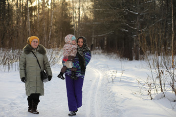 Fototapeta na wymiar Parent holding kid on hands in winter park
