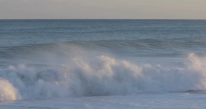Oceano e mare mosso in tempesta con onde impetuose che si infrangono sulla spiaggia.