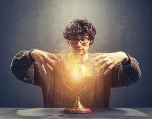 Young man gazing at the glowing crystal ball.