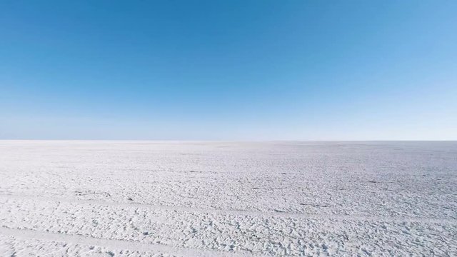 Side view of flat salt pan passing by at speed