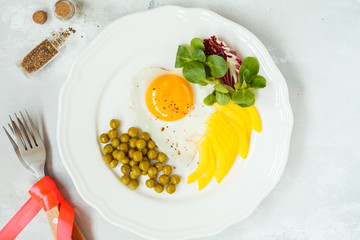 Breakfast for Valentine's Day. Fried egg heart, vegetables.  Valentine's Day concept. Top view.
