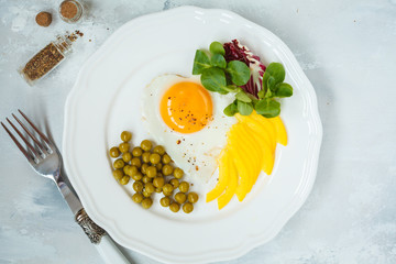 Fried egg heart, green peas, lettuce corn and pepper. Top view. Valentine's Day concept.