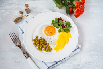 Breakfast for Valentine's Day. Fried egg heart, vegetables, bouquet of flowers. Valentine's Day concept.