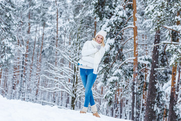 beautiful young woman walking in winter forest