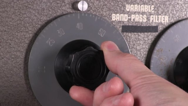 Close-up macro of increasing input cut-off frequency dial adjustment to variable band-pass filter vintage electronic hardware engineering military equipment