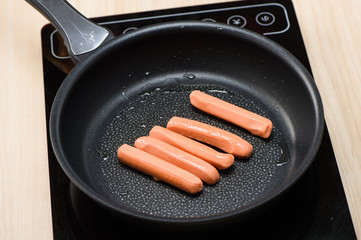 Fried sausages on Cast iron pan on wooden table
