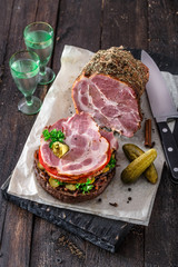 Opened homemade sandwich with smoked meat, tomato, onion jam and ico cold vodka