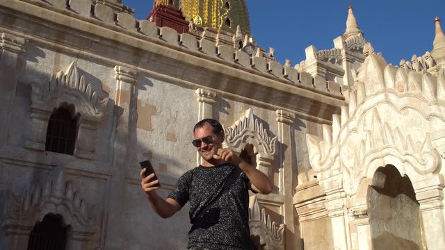 Male Tourist Taking Selfie with Temple