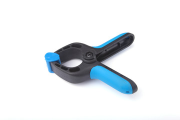 Black plastic spring clamp isolated on white background.