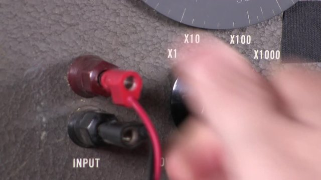 Close-up macro of input cable connection and dial setting of low cut-off frequency range selection to variable band-pass filter vintage electronic hardware engineering military equipment