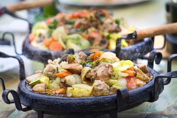 Delicious warm food with pork meat, onions, green squash, carrots and other vegetables