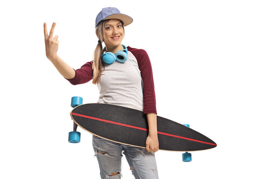 Female skater holding a longboard and making a peace sign