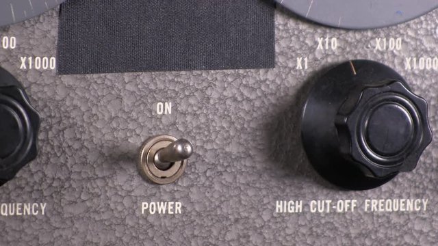 Close-up macro of power toggle switch turned on then off on variable band-pass filter vintage electronic hardware engineering military lab test equipment