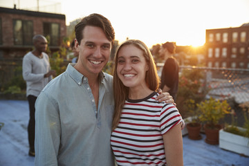 Naklejka premium Young white couple embracing at a rooftop party