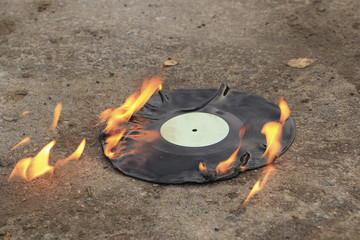 vinyl record burns bright orange flame on the asphalt