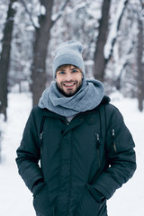 portrait of handsome smiling man looking at camera in winter park