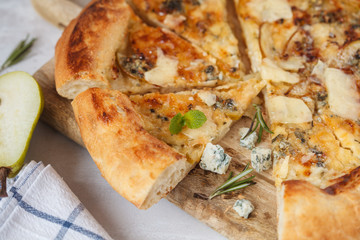 Hot delicous pizza with pear and blue cheese on wooden board. Vegetarian healthy food concept