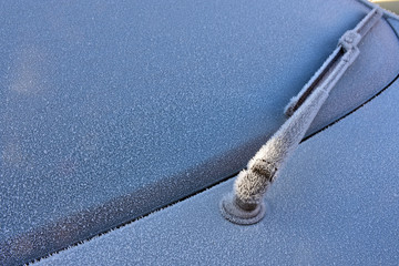 Frosted car glass and frozen wipers in the winter