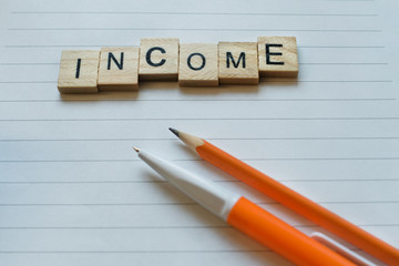 Wooden letters forming words 'income'. Concept of business, finance, account flat lay. Top view. Close up.