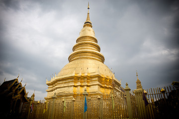 Naklejka premium The brass pagoda is glittering inside Wat Phra That Hariphunchai Woramahawihan.