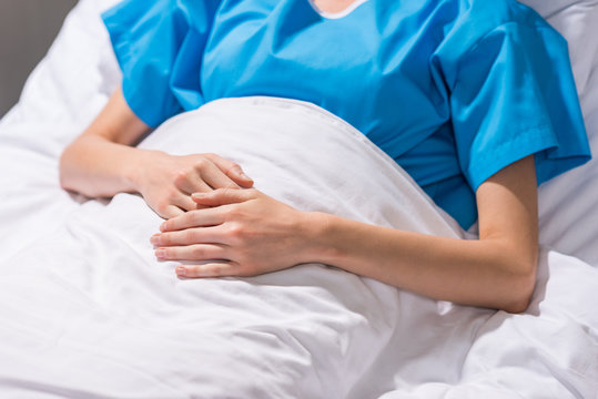 cropped image of sick woman lying on hospital bed