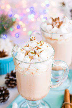 Hot cocoa with marshmallow and ground cinnamon in glasses on the table