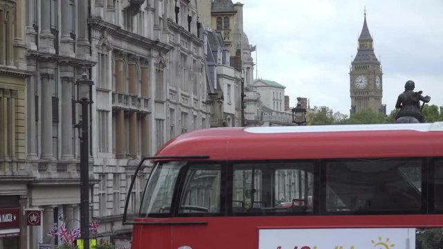 Buses pass by Big Ben and statue of George IV
