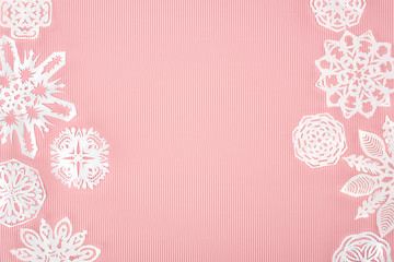 christmas background with paper snowflakes on pink