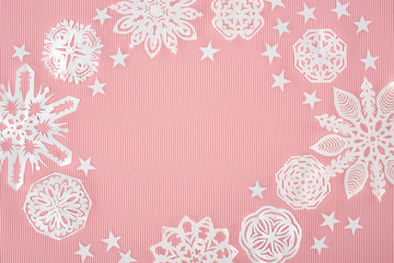 christmas frame with paper snowflakes and stars on pink background