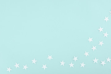 Fototapeta na wymiar background with white paper stars, isolated on light blue