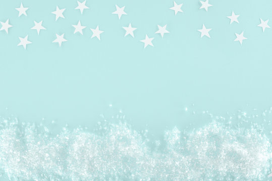 Christmas Background With Decorative Snow And Stars, Isolated On Light Blue